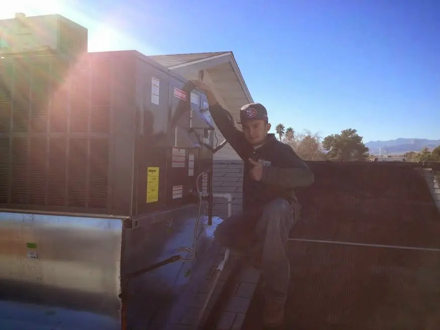 HVAC technician performing HVAC Inspection on a rooftop unit in Monroe